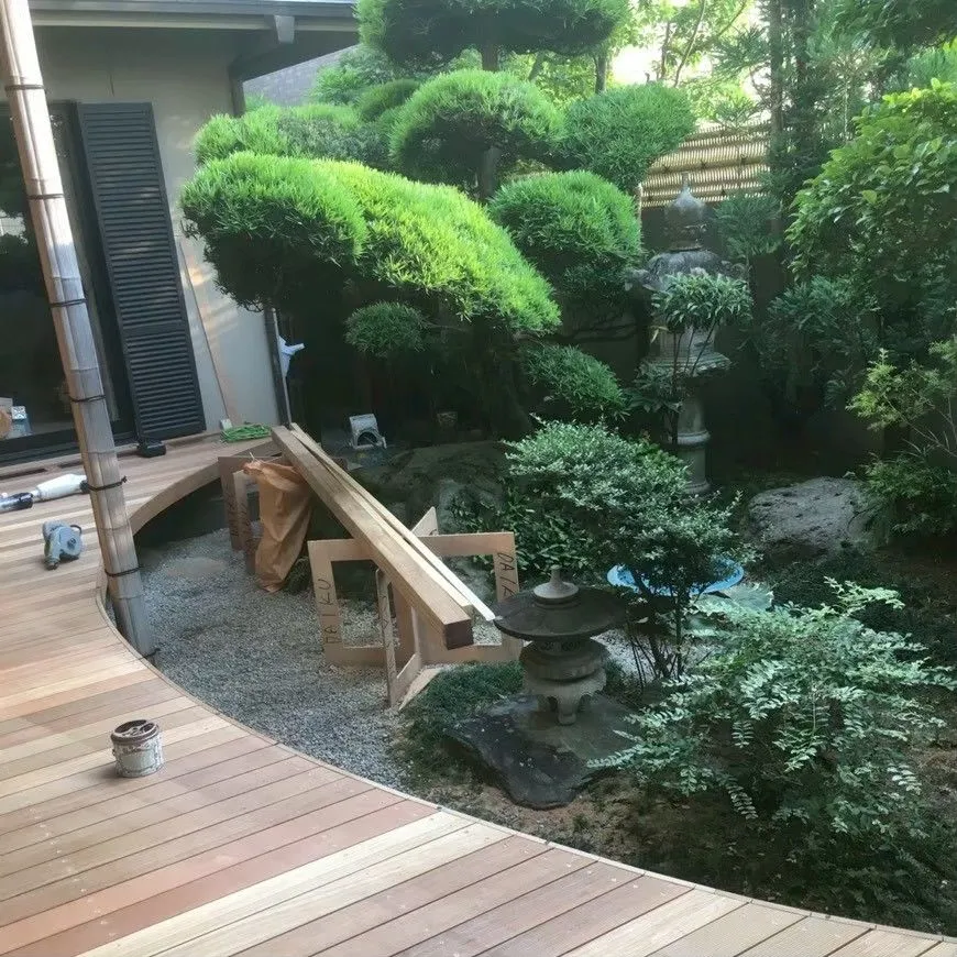 庭に沿う曲線の木製デッキ。端部に開口がある